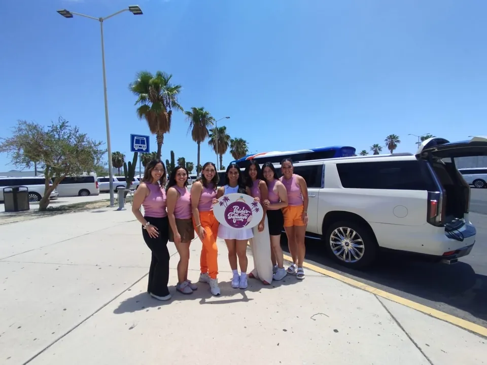 Bride's Squad posing with a white All Ways Escalade for Cabo bachelorette transportation