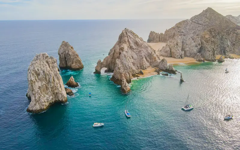 Aerial view of The Arch of Cabo San Lucas with sailboats